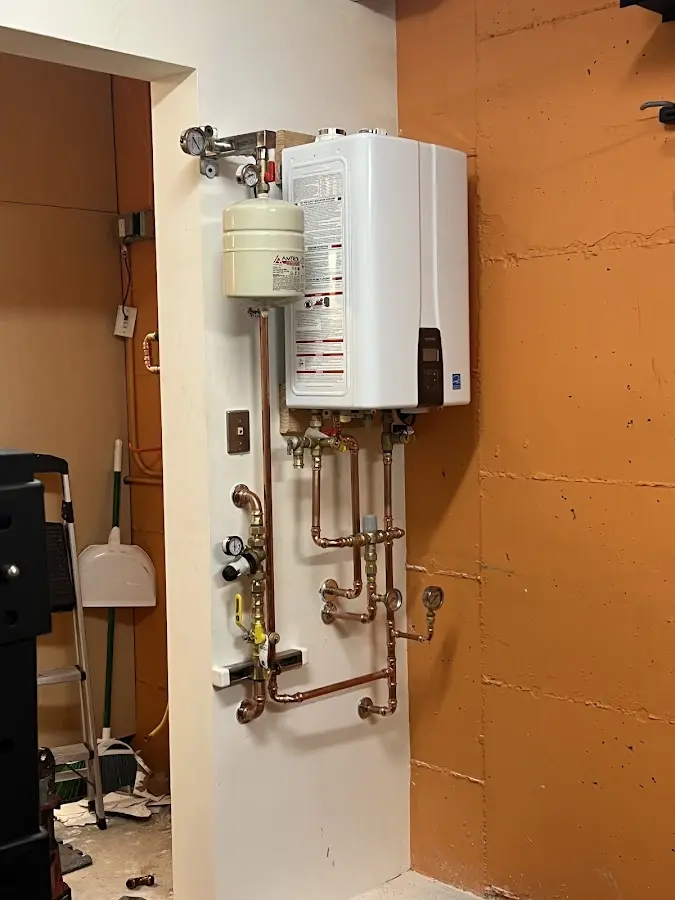 Plumbing technician inspecting water heater connections in Hephzibah
